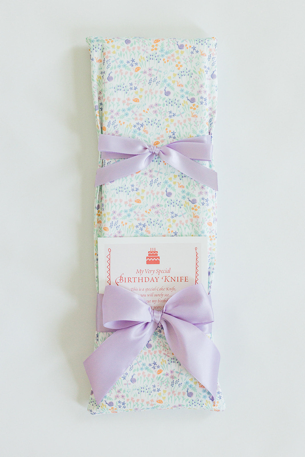 A Garden Party gift by Jubilee Keepsakes, wrapped in pastel floral paper with a lavender bow and a tag that says "My Very Special Pink Toile Birthday Knife.