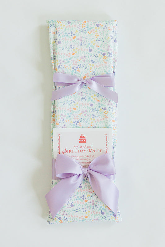 A Garden Party gift by Jubilee Keepsakes, wrapped in pastel floral paper with a lavender bow and a tag that says "My Very Special Pink Toile Birthday Knife.